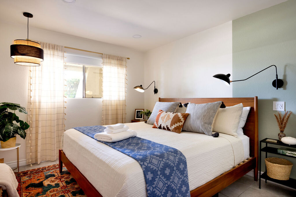 Bedroom with mid-century sconce and warm lighting at The Well
